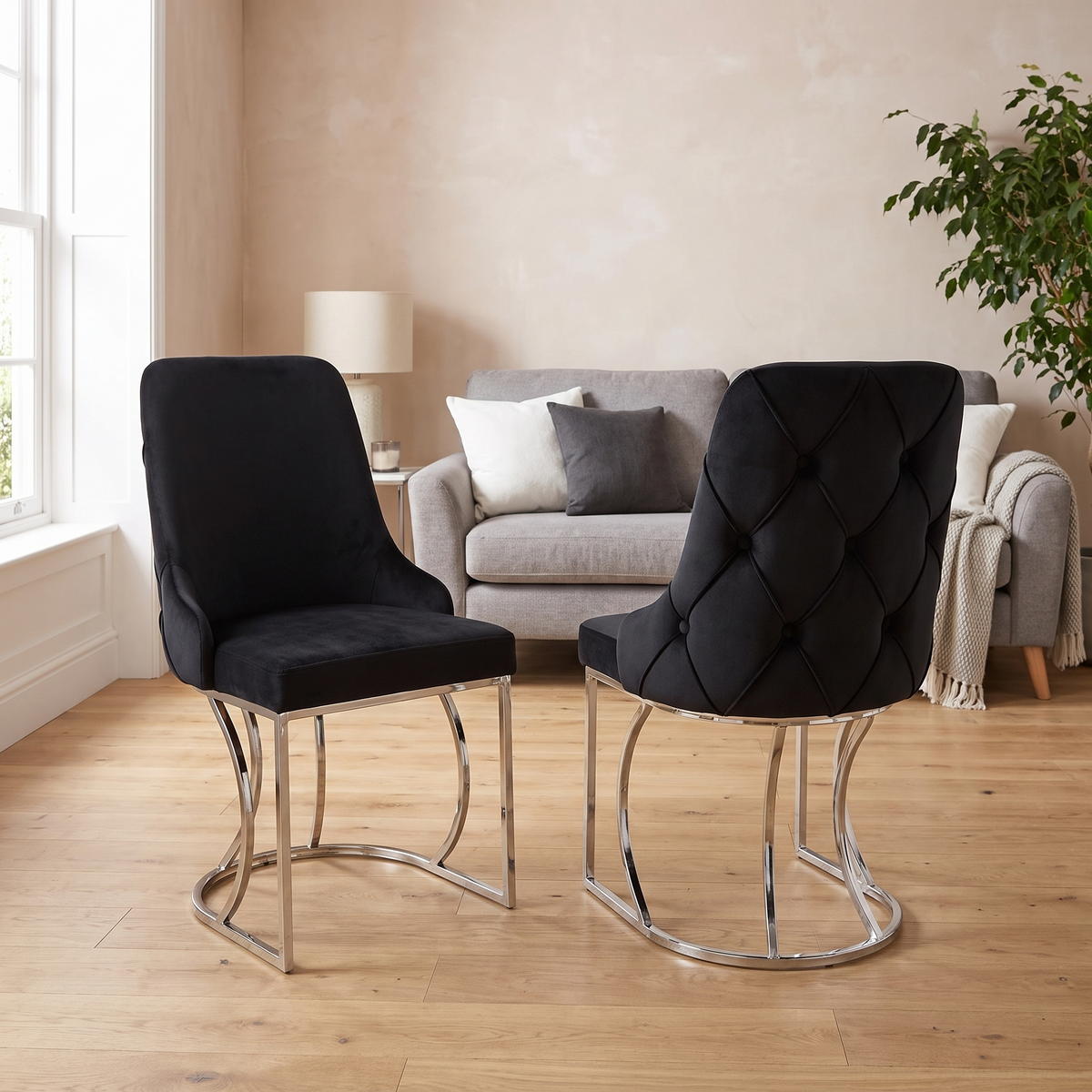 Zurich dining chairs — black velvet with scalloped fan tufting, standing on a curved polished chrome loop base rather than legs