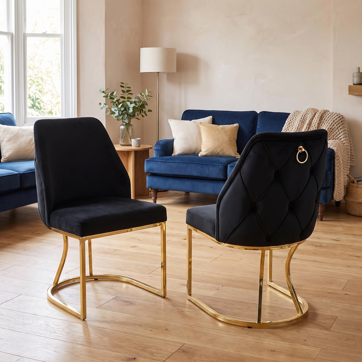 Black velvet dining chair with deep diamond buttoning and a gold ring pull on a curved gold loop base — Stockholm